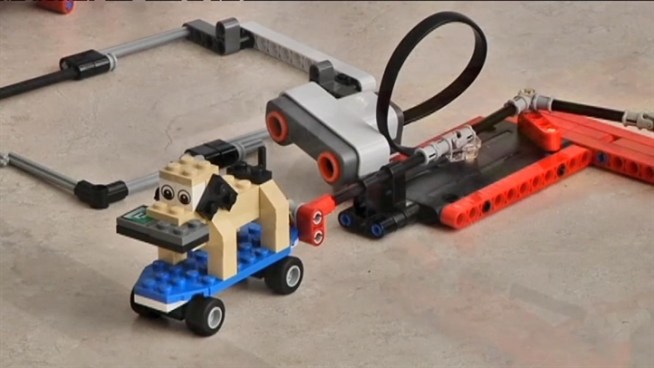 Elementary students in Fairfax County show off a Lego robot that demonstrates an invention to help older adults.