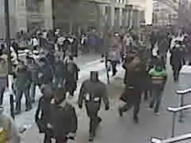 A stream of people walks along I Street toward the <a title=