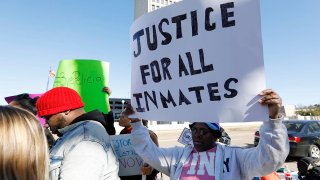 Prisoner advocates hold signs supporting inmate rights at a protest outside the Capitol in Jackson, Miss., Tuesday, Jan. 7, 2020. The protesters called on the federal government to investigate Mississippi’s prison system for possible civil rights violations. They say five deaths in recent days highlights deliberate violations of inmates’ constitutional rights.