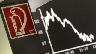 The sign for a fire extinguisher hangs next to the curve of the German stock index DAX at the stock market in Frankfurt, Germany.