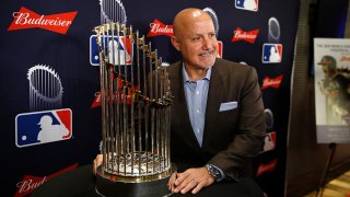 Washington Nationals general manager Mike Rizzo poses with the World Series trophy as he arrives for the premiere of a documentary film on the team’s first World Series baseball championship, Monday, Dec. 2, 2019, in Washington. (AP Photo/Patrick Semansky)