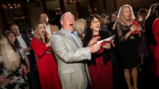 In this image released by St. John Properties, employees of the Maryland real estate firm react after finding out the company is surprising them with $10 million in bonuses at a holiday party, Saturday, Dec. 7, 2019, in Baltimore. (Wendy Hickok Photography via AP)