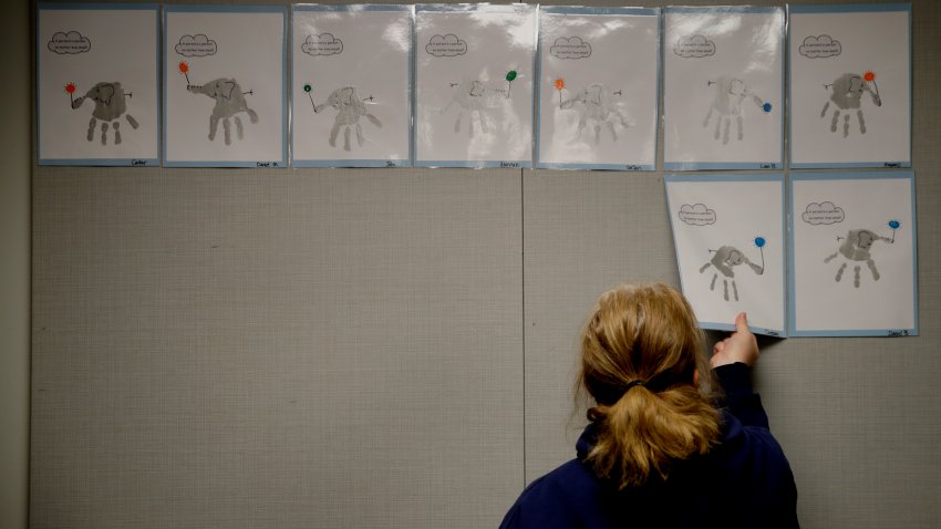 FILE - In this May 12, 2020, file photo, a teacher removes students’ artwork from a bulletin board as she packs the art in her kindergarten classroom at an elementary school in Olathe, Kan.