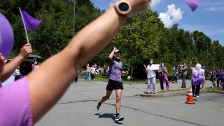 Nursing home workers cheer as Corey Cappelloni completes his seventh ultramarathon in seven days in Scranton, Pa.