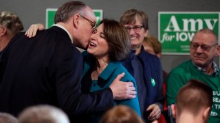 In this Feb. 1, 2020, file photo, Democratic presidential candidate Sen. Amy Klobuchar, D-Minn., center, gets a kiss from husband John Bessler upon arriving at a rally in Sioux City, Iowa.
