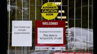A "Temporarily Closed" sign is seen in front of a store amid the coronavirus pandemic on May 14, 2020, in Arlington, Virginia.