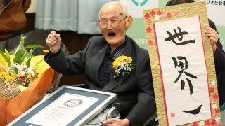 In this Japan Pool picture received via Jiji Press on February 12, 2020, 112-year-old Japanese man Chitetsu Watanabe poses next to calligraphy reading in Japanese 'World Number One' after he was awarded as the world's oldest living male in Joetsu, Niigata prefecture.