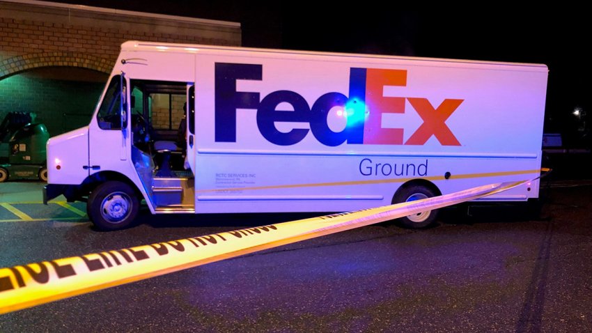 A FedEx truck in a parking lot of an Acme store, behind police tape, following a shooting in Philadelphia.