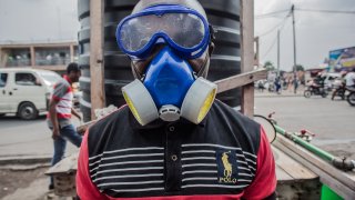 In this file image, a health worker looks on as he wears protective gear to mix water and chlorine in Goma on July 31, 2019.