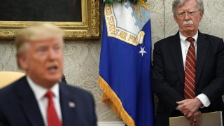 White House National Security Advisor John Bolton (R) listens to U.S. President Donald Trump as he and Dutch Prime Minister Mark Rutte talk to reporters in the Oval Office at the White House July 18, 2019 in Washington, DC.