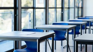 Papers on desks by windows in classroom