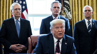 Senate Majority Leader Mitch McConnell, a Republican from Kentucky, from left, U.S. House Minority Leader Kevin McCarthy, a Republican from California, and U.S. Vice President Mike Pence listen as U.S. President Donald Trump speaks before signing the H.R. 748, Coronavirus Aid, Relief, and Economic Security (CARES) Act, in the Oval Office of the White House in Washington, D.C., U.S., on Friday, March 27, 2020. Trump signed the largest stimulus package in U.S. history today, a $2 trillion bill intended to rescue the coronavirus-battered economy after the House approved it earlier.