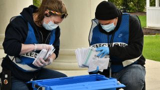 Maryland Board of Elections workers count and collect ballots dropped off at an official ballot drop box.