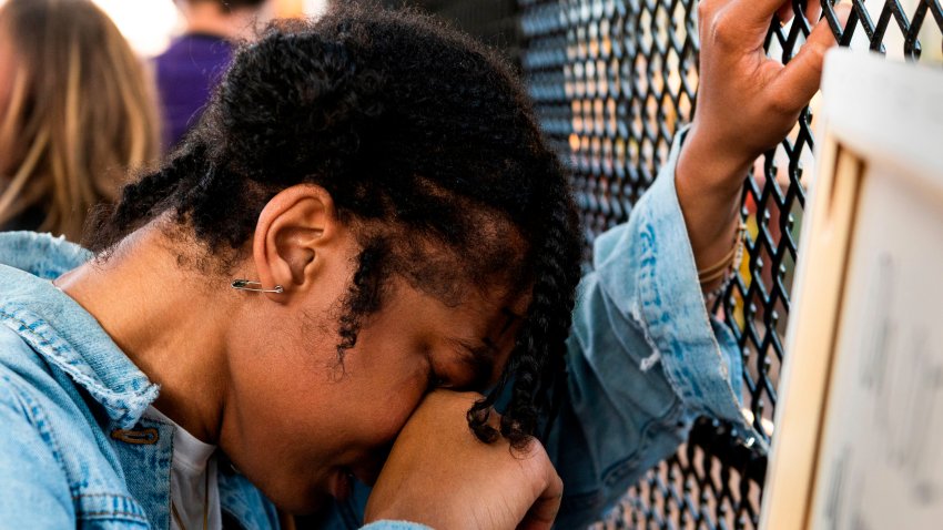 A woman cries as she is overcome by emotion after berating a line of policemen through a metal fence recently erected in front of the White House to keep protestors at bay on June 2, 2020. – Protesters returned to the area after they were tear gassed on June 1, 2020, to open the way for US President Donald Trump to walk to the church for a photo-op. (Photo by ROBERTO SCHMIDT / AFP) (Photo by ROBERTO SCHMIDT/AFP via Getty Images)