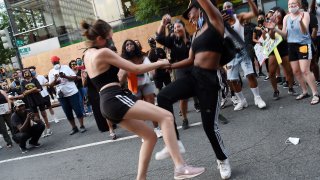 Demonstrators dance in the street near the White House during a demonstration against racism and police brutality, in Washington, DC on June 6, 2020. – Demonstrations are being held across the US following the death of George Floyd on May 25, 2020, while being arrested in Minneapolis, Minnesota. (Photo by Olivier DOULIERY / AFP) (Photo by OLIVIER DOULIERY/AFP via Getty Images)