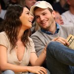 Ashton Kutcher and Mila Kunis smile during basketball game