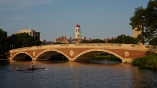 In a file photo, a sculler rows on the Charles River past the Harvard University campus in Cambridge, Massachusetts, U.S., on Tuesday, June 30, 2015. Harvard University, established in 1636, is the United States' oldest institution of higher learning. Photographer: Victor J. Blue/Bloomberg via Getty Images