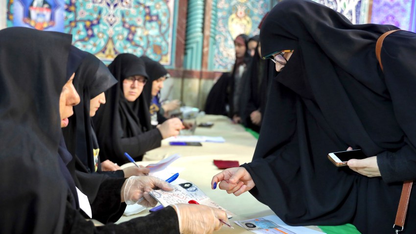 A voter registers to cast her vote during the parliament elections at a polling station in Tehran, Iran, Friday, Feb. 21, 2020. Iranians began voting for a new parliament Friday, with turnout seen as a key measure of support for Iran's leadership as sanctions weigh on the economy and isolate the country diplomatically.