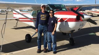 A picture of Joyce Lin in front of a light plane taken from her Facebook page.