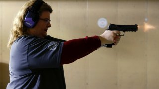 In this Wednesday, Feb. 5, 2020, photo, Kat Ellsworth of Chicago, fires her Sig Sauer P320 X-Five Legion hand gun, one of the seven guns she owns, at the Caliber Tactical Gun Range in Waukegan, Ill. As a registered Democrat, if she could give Democratic presidential candidates any advice, she said, it would be this: “I feel like they would really gain a lot more votes if they would just drop the gun-control crap.”