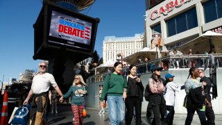 People walk near the Paris Las Vegas hotel casino, site of a Democratic presidential debate, Wednesday, Feb. 19, 2020, in Las Vegas. Nevada's first-in-the West presidential caucus puts the spotlight Saturday on a state that has swung increasingly blue over the last two decades.
