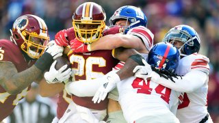Adrian Peterson is tackled by David Mayo and Markus Golden in the first quarter at FedEx Field.