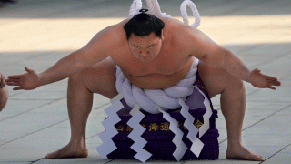 In this Jan. 9, 2018, file, photo, Sumo grand champion Hakuho of Mongolia performs his ring entry form at the Meiji Shrine in Tokyo.