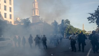 Tear gas floats in the air as a line of police move demonstrators away from St. John's Church across Lafayette Park from the White House, as they gather to protest the death of George Floyd, Monday, June 1, 2020, in Washington.