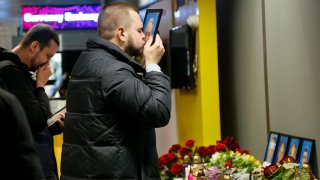 In this Jan. 8, 2020, file photo, the partner of Julia Sologub, a member of the flight crew of the Ukrainian 737-800 plane that crashed on the outskirts of Tehran, kisses a portrait of her at a memorial inside Borispil international airport outside Kyiv, Ukraine.