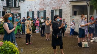 Socially distanced crowd with masks, applauding