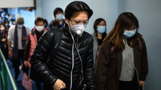 In this Feb. 5, 2020, file photo, passengers wearing face masks alight from a ferry in Hong Kong as a preventative measure following a virus outbreak which began in the Chinese city of Wuhan.