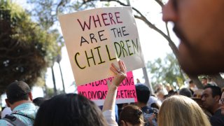 A protester holds a sign at the 'Families Belong Together March' against the separation of children of immigrants from their families