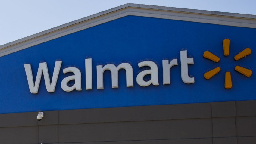 In this July 16, 2020, file photo, an employee wearing a protective mask pulls carts towards a Walmart store in Lakewood, California.