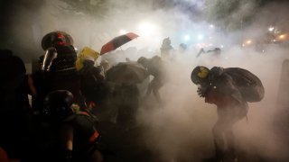 Federal officers launch tear gas at a group of demonstrators during a Black Lives Matter protest at the Mark O. Hatfield United States Courthouse Sunday, July 26, 2020, in Portland, Ore.