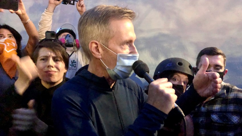 Mayor Ted Wheeler speaks to people gathered in downtown Portland, Ore., Wednesday, July 22, 2020. Wheeler faced a hostile crowd of protesters, who screamed at and sharply questioned him as he tried to rally demonstrators who have clashed repeatedly with federal agents sent in by President Donald Trump to quell ongoing unrest in the city.