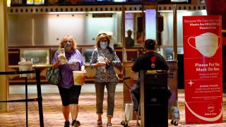 Two women pass by the ticket checkpoint at an AMC theater