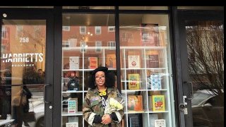 Woman standing in front of her bookshop in Philadelphia