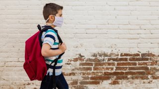 child with face mask backpack