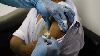 In this Sept. 9, 2020, file photo, a health worker injects a person during clinical trials for a COVID-19 vaccine at Research Centers of America in Hollywood, Florida.