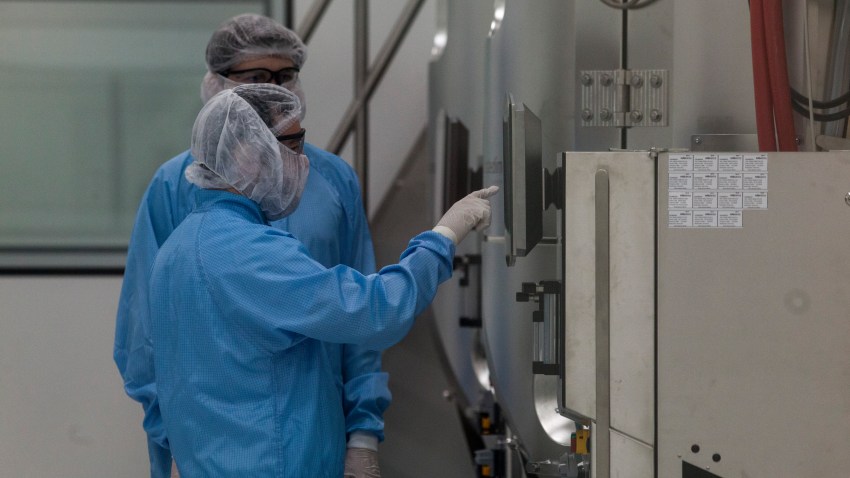 GARIN, ARGENTINA - AUGUST 13: Laboratory workers wearing PPE check a screen of a centrifuge machine at the production plant of mAbxience biotechnology company on August 13, 2020 in Garín, Argentina. The Argentina lab, property of Grupo Insud, will co-manufacture with Mexico the coronavirus vaccine created by Oxford University and Swedish-British pharmaceutical firm AstraZeneca.