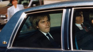 John Hinckley, Jr., accused assassinate of President Reagan, sits in the back of this motioned vehicle outside the federal court in DC shortly after asking for permission to visit his family for Easter without supervision, Jan. 1, 1990.