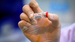 This picture taken on May 23, 2020, shows a laboratory technician holding a dose of a COVID-19 vaccine candidate ready for trial on monkeys at the National Primate Research Center of Thailand at Chulalongkorn University in Saraburi.