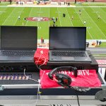 Two laptops in a road case sit on a balcony overlooking the 49ers' football field at Levi's Stadium.