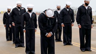 Sailors of the USS Cole bow their heads during a benediction following a remembrance ceremony commemorating the 20th anniversary of the attack on USS Cole