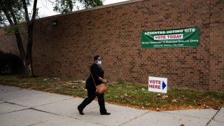 A person walks to cast absentee ballot