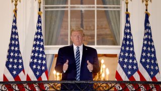 Donald Trump gives two thumbs up outside of the White House.