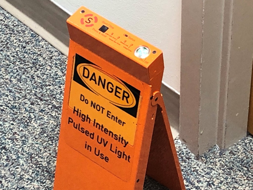A sign warns of UV light in use.