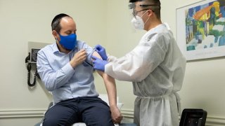 Rabbi Shmuel Herzfeld has his arm disinfected by Dr. Chao Wang during a clinical trial for a Coronavirus vaccine at Meridian Clinical Research in Rockville, Maryland on Monday, July 27, 2020. The Coronavirus vaccine was created by the biopharmaceutical company Moderna.