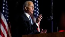 Joe Biden speaks with American flags in background