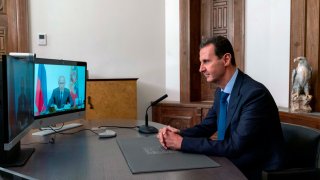 President Bashar Assad listens to Russian President Vladimir Putin